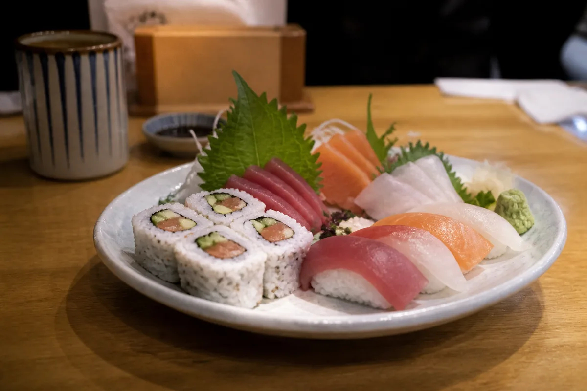 Assiette japonaise avec makis, nigiris et tranches de sashimi dans un restaurant sobre
