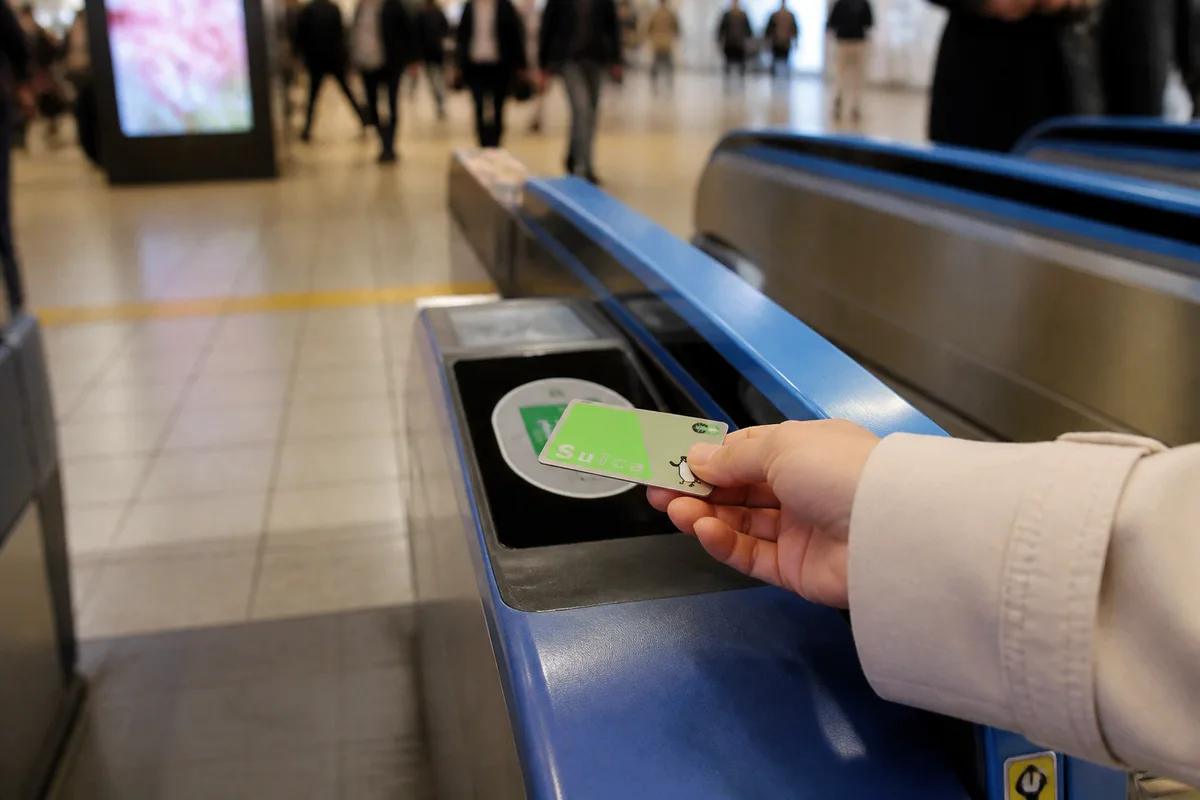 Carte IC japonaise utilisée pour payer un trajet dans une gare de Tokyo