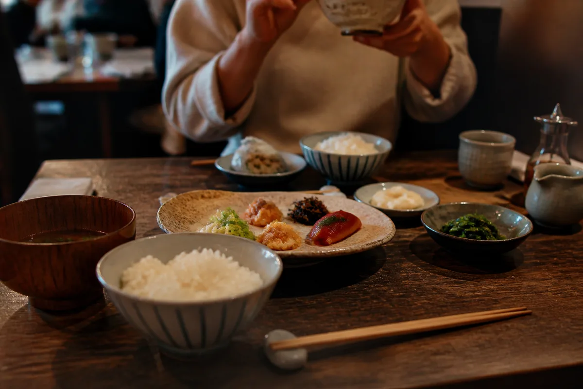 Repas japonais avec baguettes posées correctement sur un repose-baguettes dans un restaurant